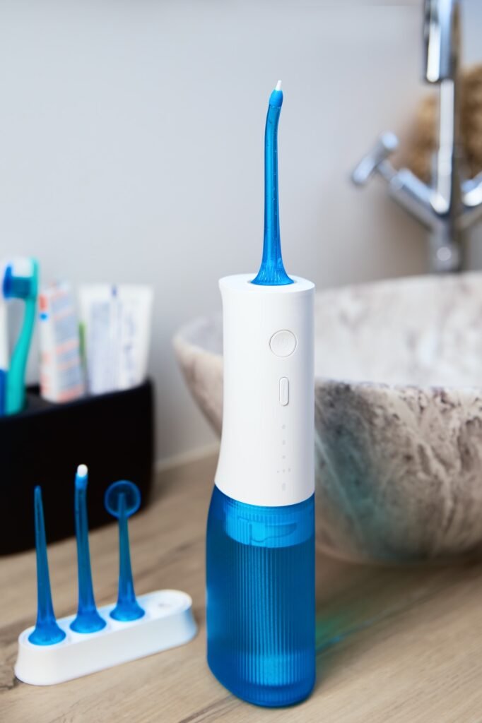 Portable oral irrigator kit in bathroom, waterpik for family use